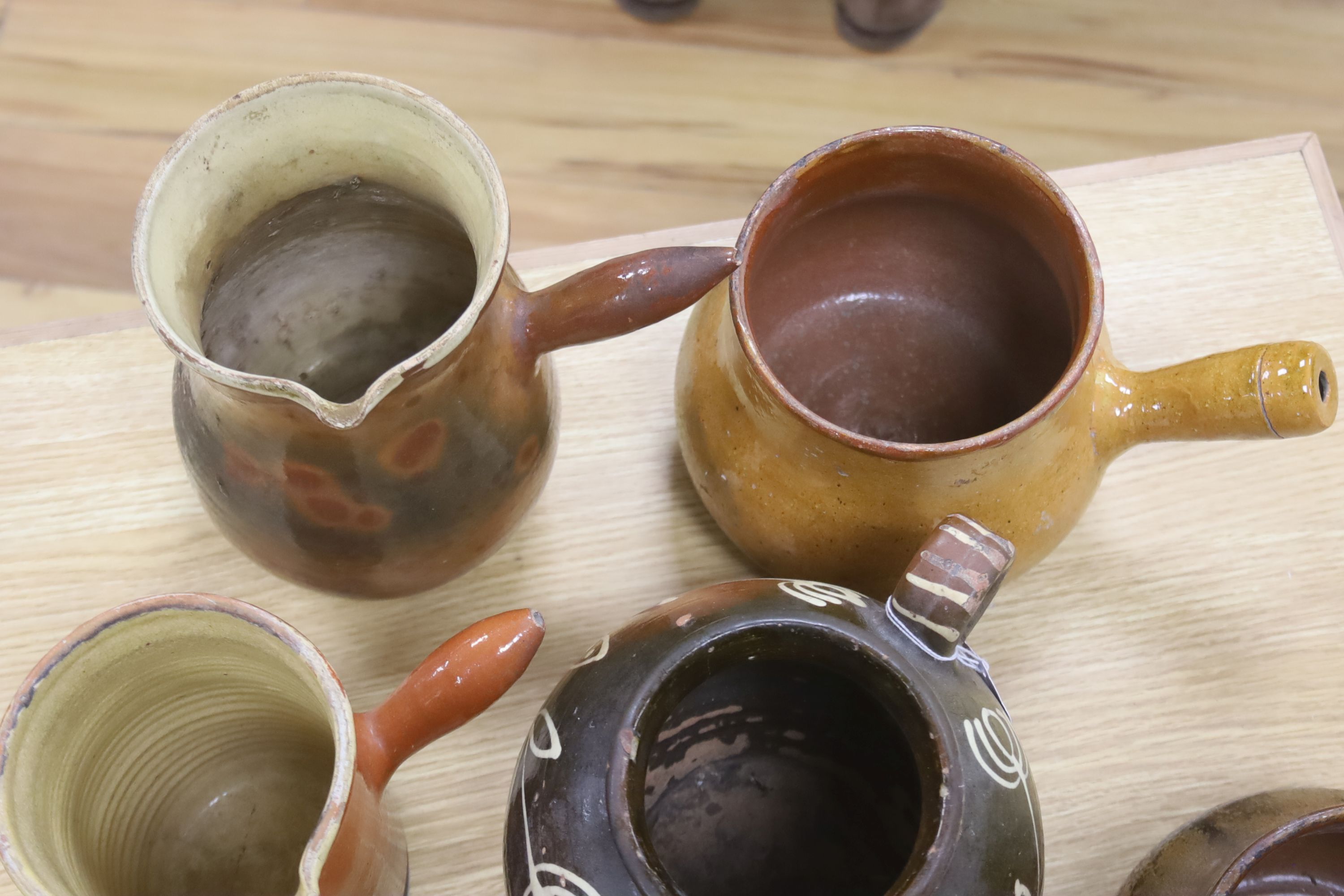 Six vintage Continental, probably French, glazed stoneware cooking pots and a slip-decorated stoneware confit pot